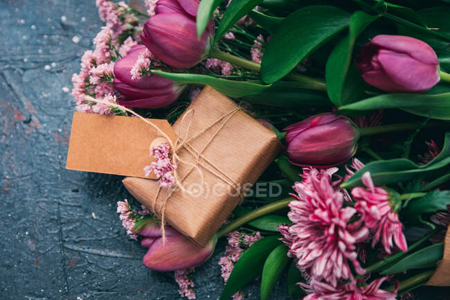 Fleurs tulipes avec boîte-cadeau enveloppée — Photo de stock
