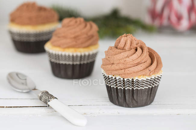 Três cupcakes de chocolate em uma fileira, vista close-up — Fotografia de Stock