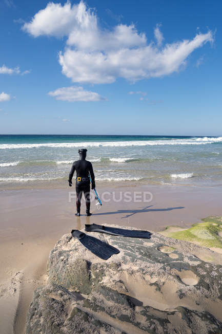 Homem de fato de mergulho em pé na praia, Los Lances, Tarifa, Cádiz, Andaluzia, Espanha — Fotografia de Stock