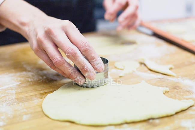 Imagem cortada de mulher usando cortador de biscoitos na massa — Fotografia de Stock