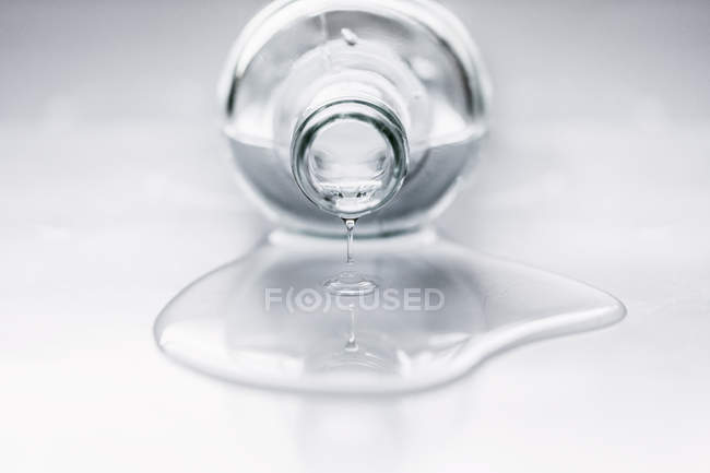 Flasche auf Tisch liegend, Wasser kommt heraus — Stockfoto