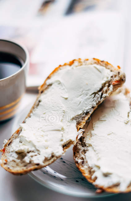 Vista de primer plano de café y tostadas con queso crema - foto de stock