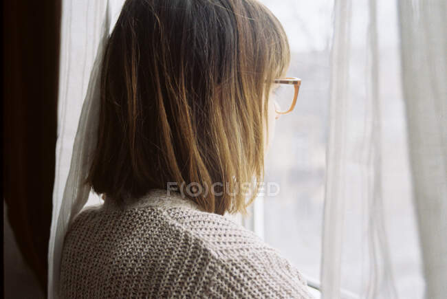 Mulher olhando pela janela — Fotografia de Stock