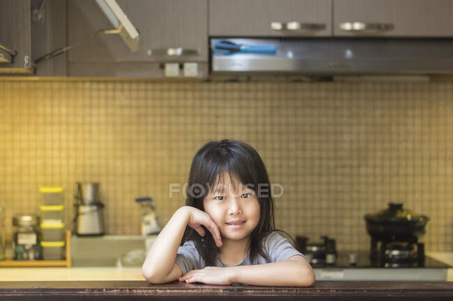 Усміхнена дівчина стоїть на кухні — стокове фото