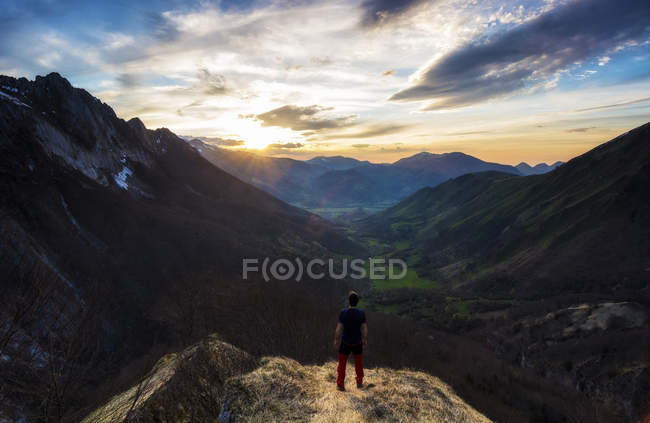 Hombre de pie en las montañas al atardecer, Pirineos, Francia - foto de stock