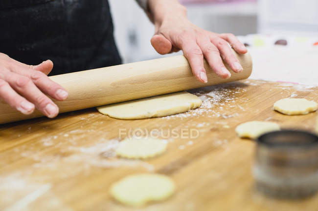 Обрезанный образ женщины, выкатывающей свежее тесто — стоковое фото