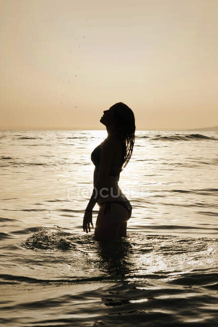 Silueta de una mujer parada en el mar, Tarifa, Cádiz, Andalucía, España - foto de stock