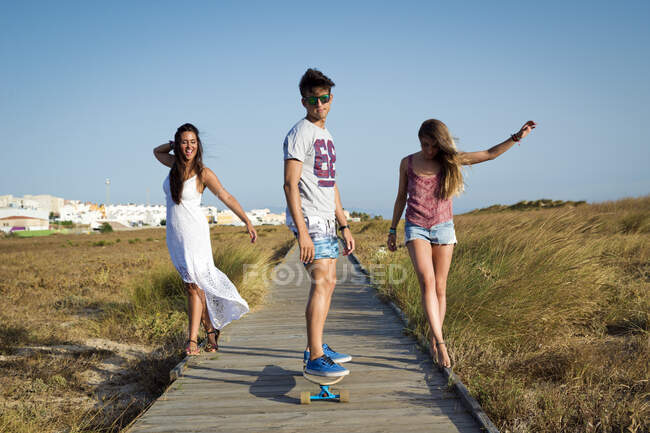 Three people walking along boardwalk, Tarifa, Cadiz, Andalucia, Spain — Stock Photo