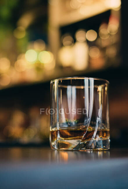 Un vaso de whisky en un bar - foto de stock