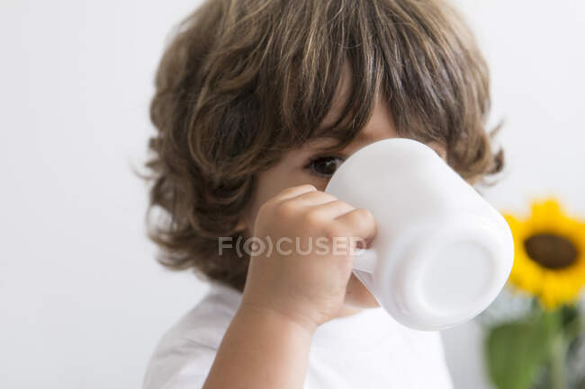 Крупным планом портрет мальчика, пьющего из кружки — стоковое фото