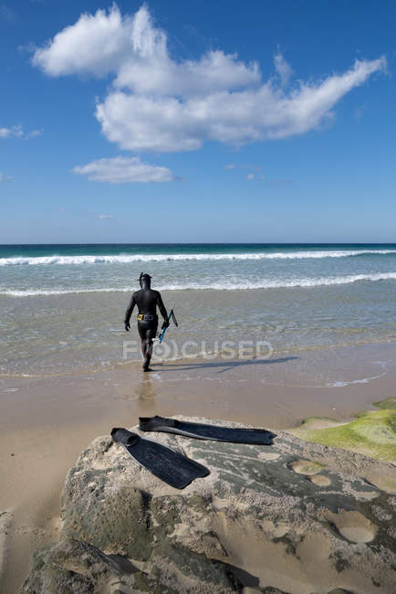 Homem de fato de mergulho caminhando no oceano, Los Lances, Tarifa, Cádiz, Andaluzia, Espanha — Fotografia de Stock
