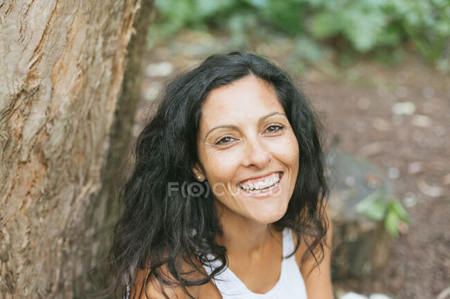 Portrait d'une femme souriante sur fond naturel — Photo de stock