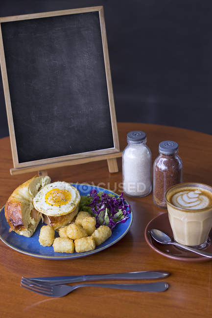 Petit déjeuner, café et tableau blanc sur la table — Photo de stock