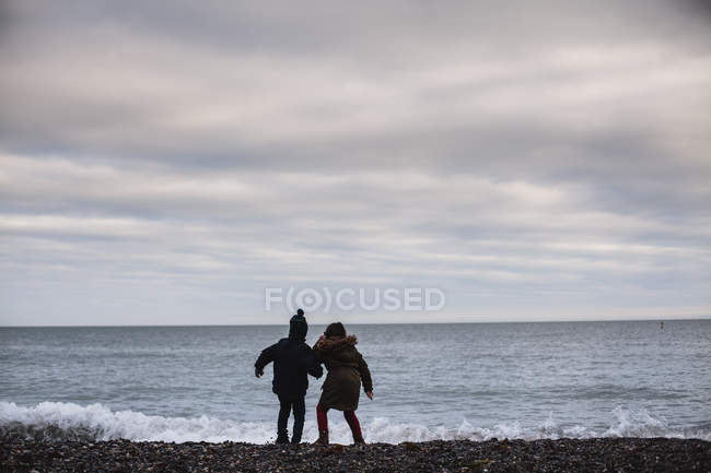 Заднього вигляду хлопчик і дівчинка на пляжі, Сполучені Штати Америки — стокове фото