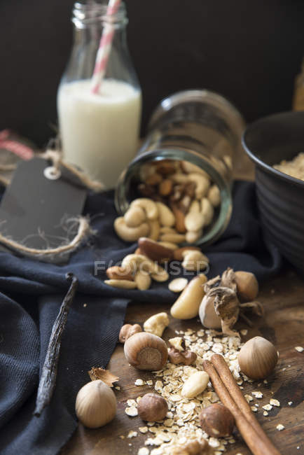 Nuts, oats and cinnamon sticks with milk — Stock Photo