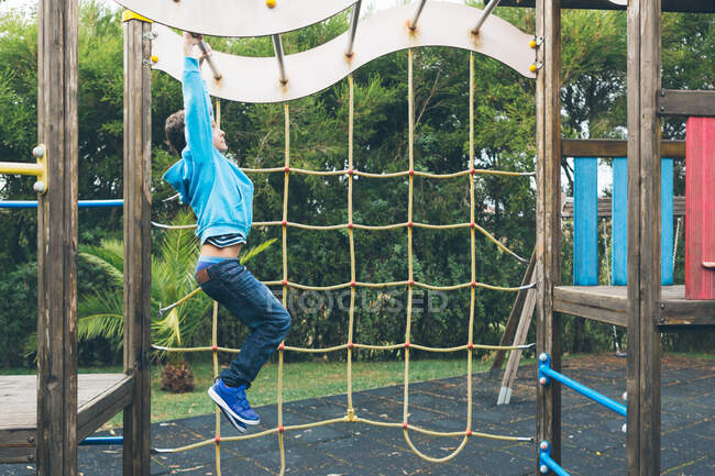 Garçon jouant dans une aire de jeux — Photo de stock