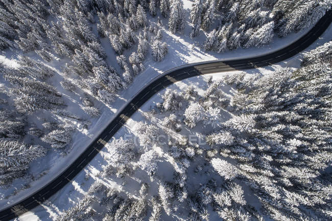 Vista aérea de un camino serpenteando a través de un paisaje invernal, Salzburgo, Austria - foto de stock
