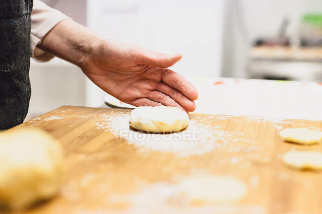 Cropped image of woman shaping fresh dough — Stock Photo