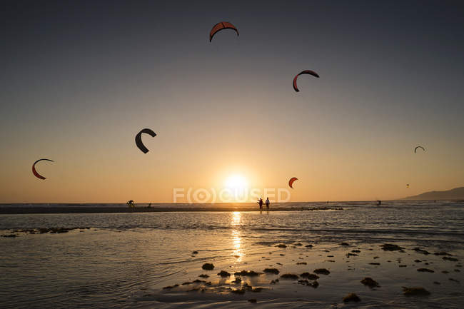 Silhueta de kitesurfistas ao pôr-do-sol, praia Los Lances, Espanha — Fotografia de Stock