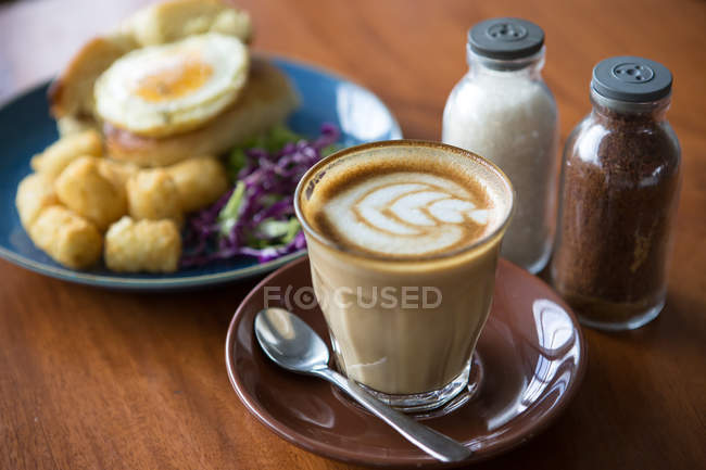 Breakfast bagel with fried egg and coffee — Stock Photo