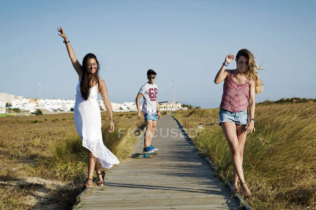 Tre persone che camminano lungo il lungomare, Tarifa, Cadice, Andalusia, Spagna — Foto stock