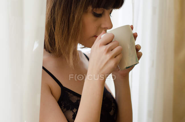 Retrato de una hermosa joven bebiendo café - foto de stock