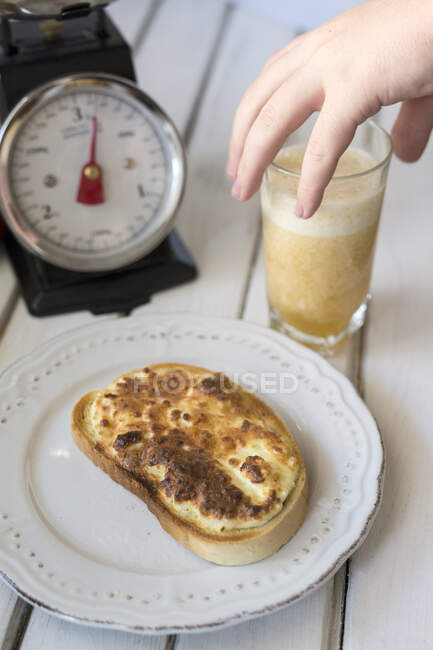 Niño alcanzando para smoothie en el desayuno - foto de stock