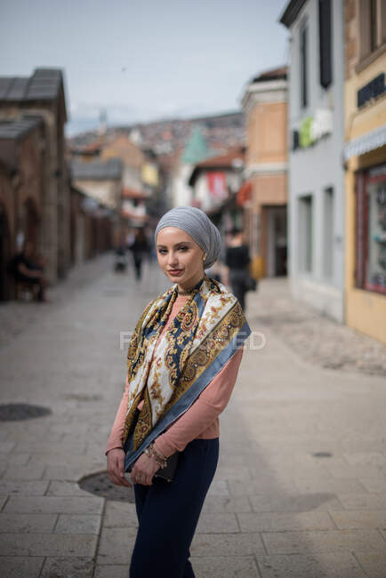 Femme portant un foulard debout dans la rue — Photo de stock