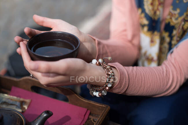 Mani di donna che tengono una tazza di tè — Foto stock