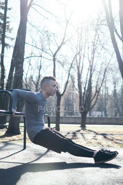 Man doing reverse push-up in park, Minsk, Belarus — Fotografia de Stock