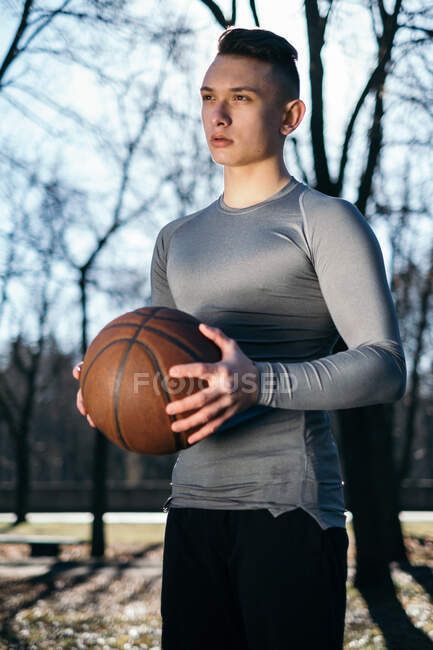 Mann steht im Park und hält Basketball, Minsk, Weißrussland — Stockfoto