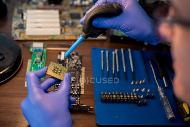 Técnico de limpieza de un chip de ordenador - foto de stock