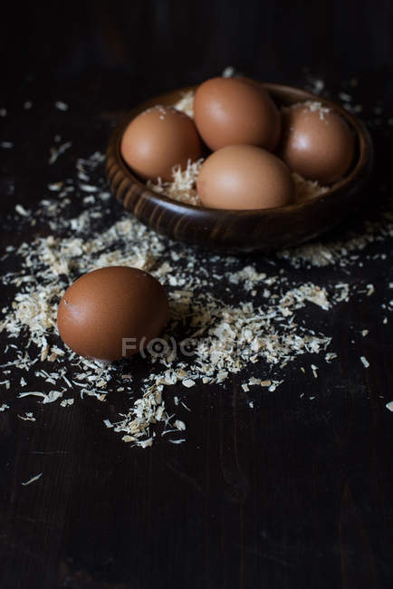 Primo piano vista delle uova in una ciotola di legno con segatura — Foto stock
