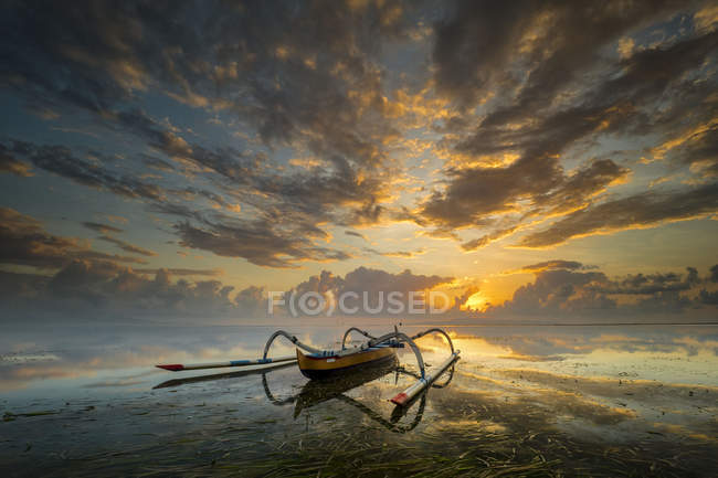 Мальовничий вид на традиційні сміттєві човни на заході сонця, пляж Санур, Балі, Індонезія — стокове фото
