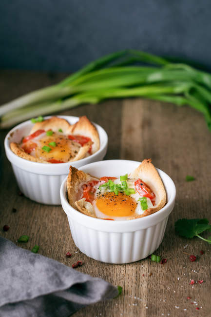 Baked eggs with tomatoes, bread and scallions — Stock Photo
