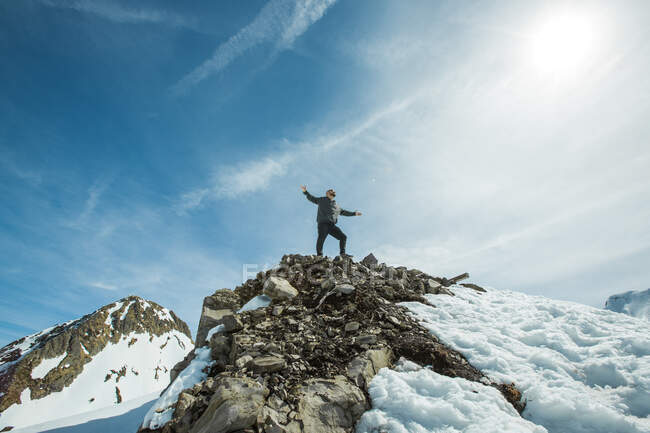 Man standing on mountain summit with arms outstretched, Chamonix, France - foto de stock