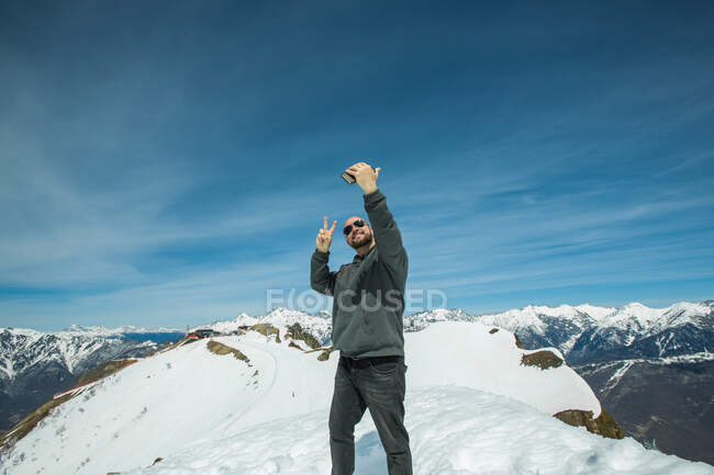 Чоловік, що стоїть на вершині гори і бере собі селфі (Шамоні, Франція). — стокове фото