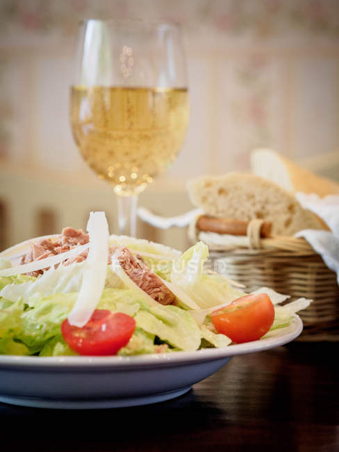 Closeup view of Tuna salad with a glass of white wine — Stock Photo