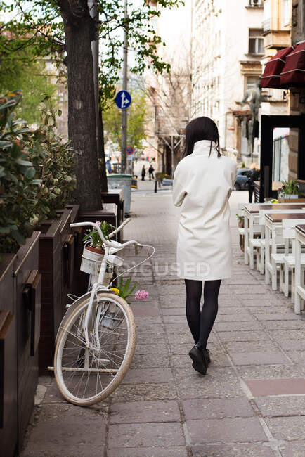Woman walking down city street — Stock Photo