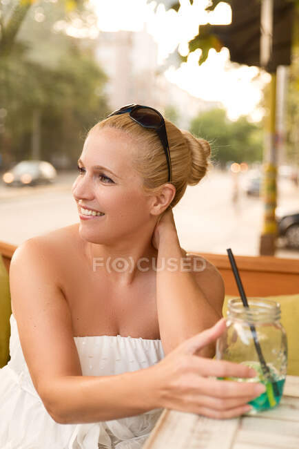 Жінка сидить у кафе з коктейлем — стокове фото