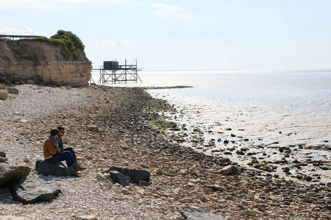 Uomo e donna seduti sulla spiaggia — Foto stock