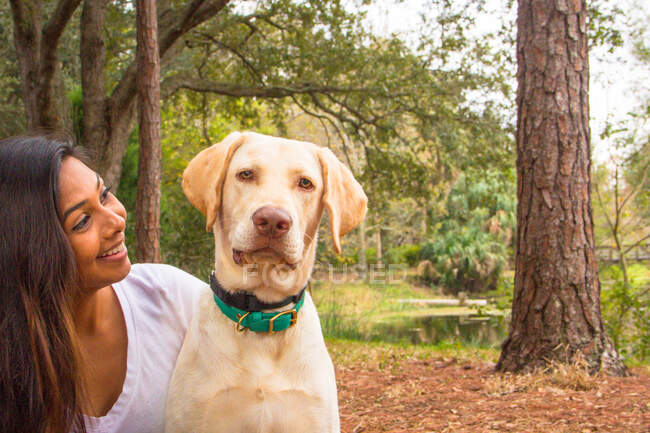 Frau sitzt mit Hund im Wald, Sankt Petersburg, Florida, Amerika, USA — Stockfoto