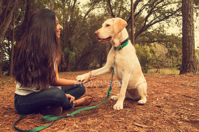 Donna seduta nella foresta con un cane, San Pietroburgo, Florida, America, USA — Foto stock