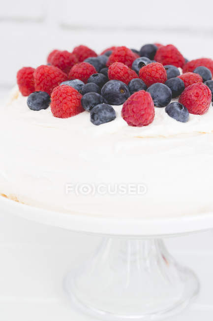 Pavlova with blueberries and raspberries over white background — Stock Photo