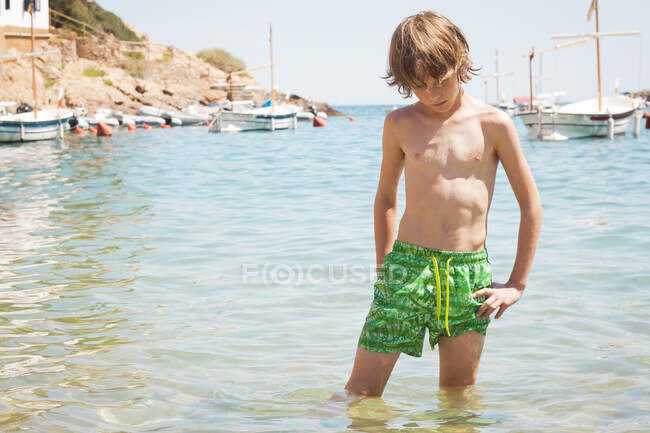 Мальчик, стоящий в море, Бегур, Жирона, Каталония, Испания — стоковое фото
