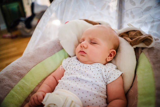 Baby boy sleeping in a baby bouncer — Stock Photo