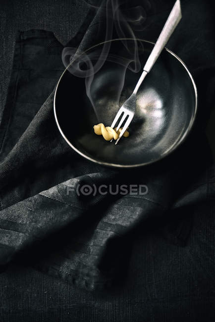 Bowl and a fork with one fusilli pasta — Stock Photo