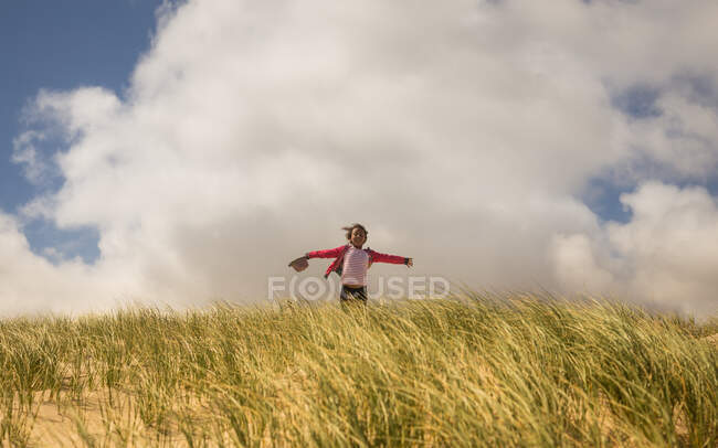 Chica corriendo en dunas de arena - foto de stock
