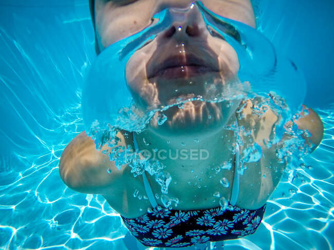 Ragazza che nuota sott'acqua in piscina — Foto stock