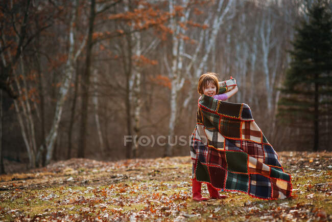 Chica envuelta en una manta girando alrededor - foto de stock